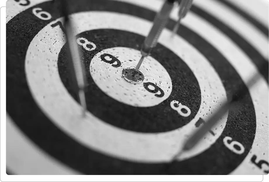 A monochrome image of a dart hitting a target.